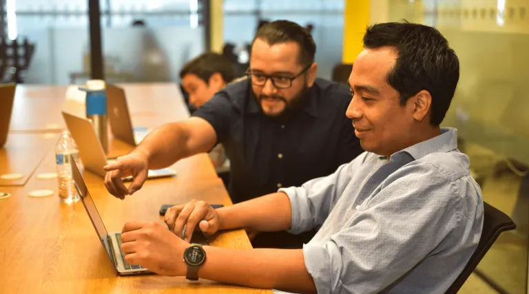 Two team members discussing work on a laptop